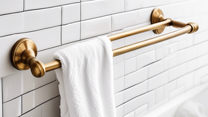 A vintage brass towel bar with a fluffy white towel hanging on it, against a backdrop of white subway tiles.